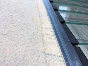 窓目地のシーリング部分に亀裂があり、水分の浸入リスクが高まっている外壁の写